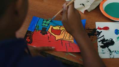 Leerling die zijn eigen versie van De slaapkamer van Van Gogh schildert tijdens een les van het DHL x Van Gogh Museum Heart for Art-programma. Foto: Mals Media 