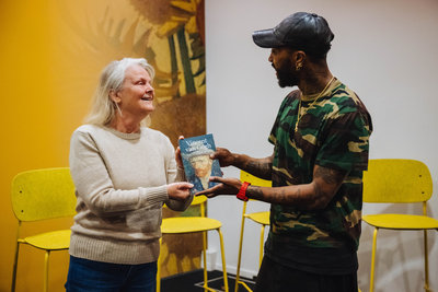 Muzikant Ray Fuego overhandigt het eerste exemplaar van het boek ‘Vincent van Gogh, zijn leven’ aan Jantine van Gogh. Foto: Jelle Draper