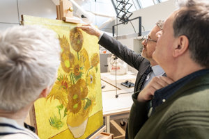 Axel Rüger, former Director of the Van Gogh Museum, points to the added wooden strip in the museum's conservation studio together with restorers Ella Hendriks and René Boitelle (conservators).