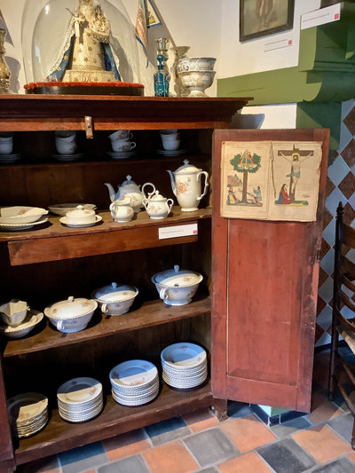 Schapraai uit omstreeks 1885 met een karakteristiek devotioneel arrangement: een huiszegen aan de binnenzijde van de deur (hier vanwege het formaat op een los karton geplakt) en bovenop een stolpmadonna met aan weerszijden een glazen sierkandelaar met kwikzilver waarin bedevaartvaantjes zijn geplaatst (Collectie Maas-Rooijakkers, Museum ’t Oude Slot, Veldhoven). 