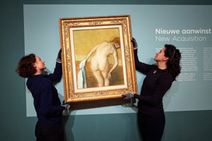 Conservator en collectiemedewerker hangen nieuwe aanwinst Degas op