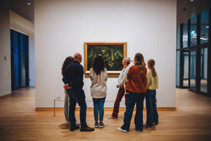 Bezoekers kijken tijdens een rondleiding naar het schilderij De aardappeleters van Vincent van Gogh. Foto: Jelle Draper