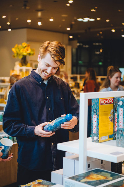 Een bezoeker kijkt naar een Van Gogh-thermosfles in de museumwinkel. Foto: Jelle Draper