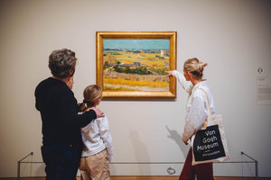 A family is looking at the painting The Harvest by Vincent van Gogh during a guided tour. Photo: Jelle draper
