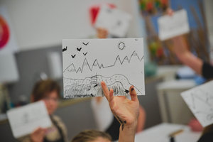 Een kinderhand houdt een tekening omhoog. Foto: David Stegenga