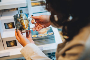 Een bezoeker houdt een Van Gogh-mok in de hand in de winkel van het Van Gogh Museum. Foto: Jelle Draper
