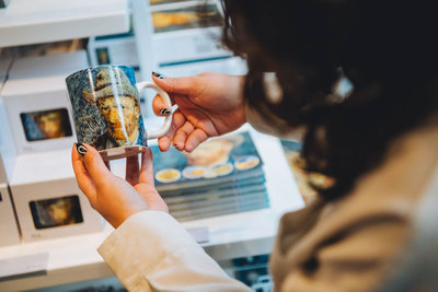 Een bezoeker houdt een Van Gogh-mok in de hand in de winkel van het Van Gogh Museum. Foto: Jelle Draper