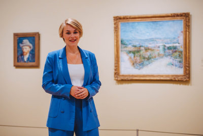 Bregje Gerritse, onderzoeker bij het Van Gogh Museum, staat voor de schilderijen 'Zelfportret met grijze vilthoed' en  'Montmartre: achter de Moulin de la Galette' van Vincent van Gogh. Foto: Jelle Draper