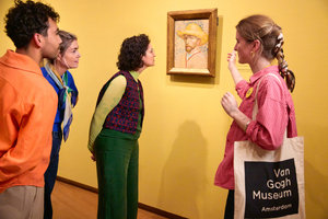 Een groepje bezoekers kijkt naar een zelfportret van Vincent van Gogh tijdens een rondleiding in het Van Gogh Museum. Foto: Suzanne Karsters