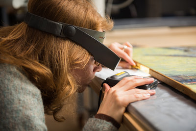 Een restaurator van het Van Gogh Museum onderzoekt een schilderij. Foto: Maartje Strijbis