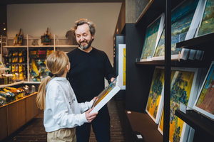Een vader en zijn dochter kijken naar canvassen met reproducties van Van Gogh schilderijen in de winkel van het Van Gogh Museum. Foto: Jelle Draper
