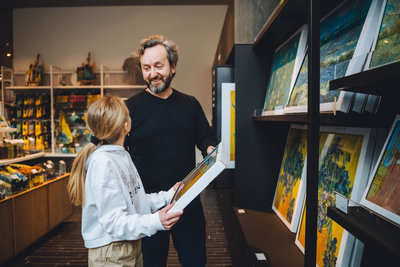 Een vader en zijn dochter kijken naar canvassen met reproducties van Van Gogh schilderijen in de winkel van het Van Gogh Museum. Foto: Jelle Draper